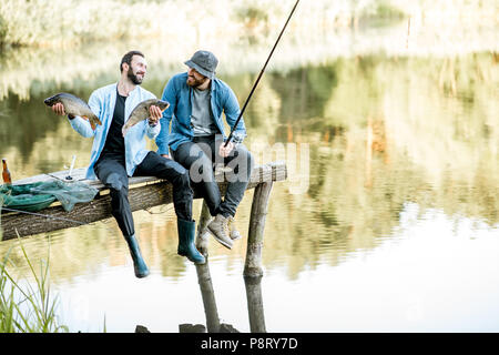 Premium Photo  Fisherman folding chair, spinning, bucket on a wooden pier  on the lake. morning fishing