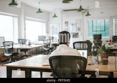 Anonymous business person working on a laptop at office desk Stock Photo