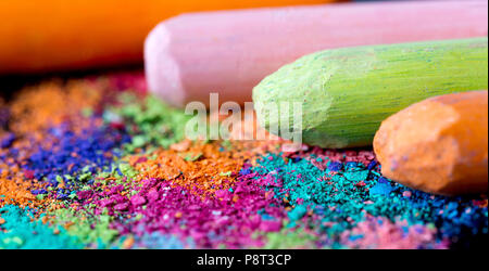 Crumbs of multi-colored chalk on a black background. Joy, Carnival, Panorama. A game for children. Art Stock Photo