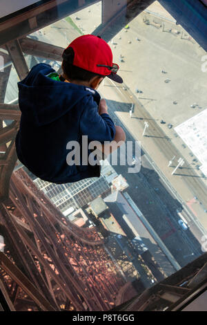 UK, England, Lancashire, Blackpool, Blackpool Tower Eye, child sat on glass walkway 500 feet above pavement Stock Photo