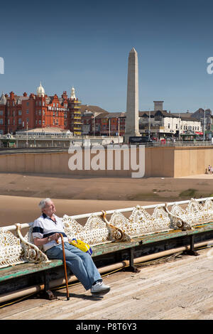 UK, England, Lancashire, Blackpool, North Pier visitor sat on bench enjoying sunshine Stock Photo