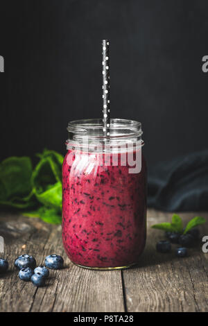 Acai smoothie in bottle on wooden table, dark background. Selective focus. Trendy superfood detox vegan drink Stock Photo