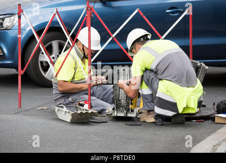 TelephTelephone engineers working on fibre optic cables on busy road in Spainone engineers Stock Photo