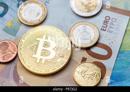 Calais, France - 17 June 2018: Bitcoin physical coin and Euro coins sitting on Euro banknotes Stock Photo