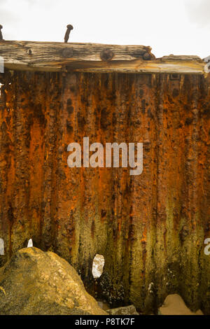 Rusted metal jetty wall on decomposing pier near Los Angeles California. Rusty, metal, red and orange Stock Photo