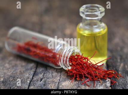 Closeup of Saffron with extract in a bottle on natural surface Stock Photo