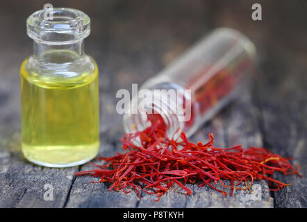 Closeup of Saffron with extract in a bottle on natural surface Stock Photo