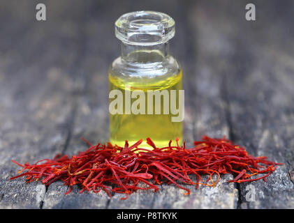 Closeup of Saffron with extract in a bottle on natural surface Stock Photo