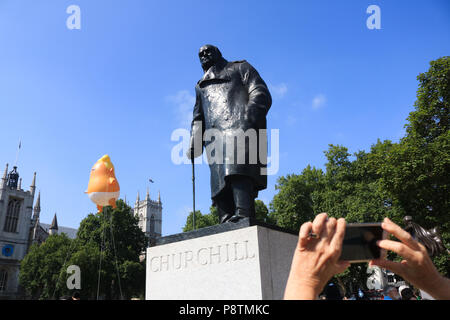 London UK. 13th July 2018. An 18 foot tall angry looking Trump Blimp rises next to the statue of Sir Winston Churchill in  is installed in Parliament Squareas a humorous protest against the UK visit of The American President Credit: amer ghazzal/Alamy Live News Stock Photo
