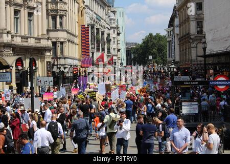 London, UK. 13th July 2018. Protestors pass through Piccadilly, London along the route that demonstrators are marching against Trump's visit to the UK 13 July 2018 also known as the Carnival of Resistance Credit: sophia akram/Alamy Live News Stock Photo