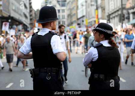 London, UK – July 13, 2018: Two members of the Metropolitan Police force chat ahead of the arrival of a demonstration to protest against US president Donald Trump in central London Credit: Dominic Dudley/Alamy Live News Stock Photo