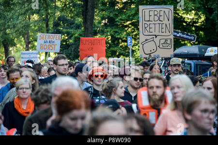 Germany, Hamburg. 13th July, 2018. Demonstrators in the district of St. Pauli carry signs reading 'Save Lifes' and 'Humanity over Border protection'. The protest for sea rescue of refugees in the Mediterranean is happening under the slogan 'Seebrücke · Schafft sichere Häfen!'. Credit: Axel Heimken/dpa/Alamy Live News Stock Photo