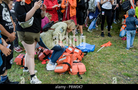 Germany, Hamburg. 13th July, 2018. Demonstrators in the district of St. Pauli wear swim vests. The protest for sea rescue of refugees in the Mediterranean is happening under the slogan 'Seebrücke · Schafft sichere Häfen!'. Credit: Axel Heimken/dpa/Alamy Live News Stock Photo