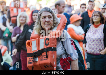 Germany, Hamburg. 13th July, 2018. Demonstrators in the district of St. Pauli wear swim vests. The protest for sea rescue of refugees in the Mediterranean is happening under the slogan 'Seebrücke · Schafft sichere Häfen!'. Credit: Axel Heimken/dpa/Alamy Live News Stock Photo