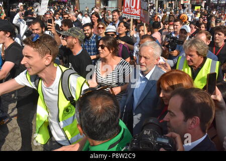 London's beloved leader of the Labour party Jeremy Corbyn takes to the streets of London on foot with very little security as he makes his way towards Leicester Square where he gave a speech in front of the thousands of people who had descended upon London today to protest the visit from American President Donald Trump. Corbyn was greeted with smiles and cheers as he once again literally rubbed shoulders with the people of London as he made his way while the crowd sang his name repeatedly along  Parliament Street past Whitehall towards the Trump protesters Stock Photo