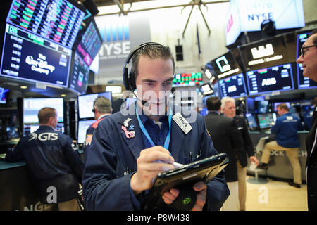 New York, USA. 13th July, 2018. A trader works at the New York Stock Exchange in New York, the United States, on July 13, 2018. U.S. stocks closed higher on Friday. The Dow Jones Industrial Average rose 94.52 points, or 0.38 percent, to 25,019.41. The S&P 500 rose 3.02 points, or 0.11 percent, to 2,801.31. The Nasdaq Composite Index rose 2.06 points, or 0.03 percent, to 7,825.98. Credit: Wang Ying/Xinhua/Alamy Live News Stock Photo