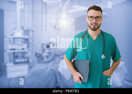 Handsome young doctor is looking at camera, in a modern operating room at hospital. Stock Photo