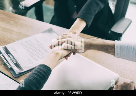 Three business partners team with hands together to greeting start up project in office. Business meeting concept Stock Photo