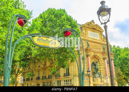 The sign of the underground in Paris in classical liberty style in Place Saint-Michel. Entrance to subway with Fontaine Saint-Michel on background. Metro sign in Paris, France, Europe. Stock Photo