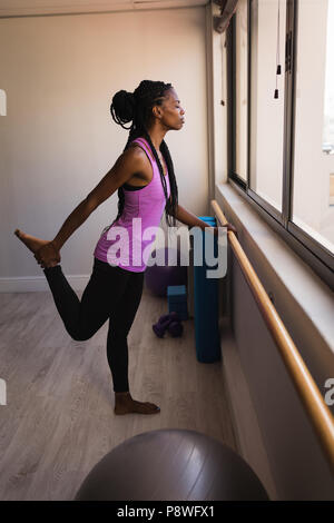 Woman performing barre exercise Stock Photo