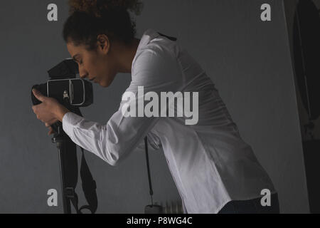 Female photographer clicking photos with digital camera Stock Photo