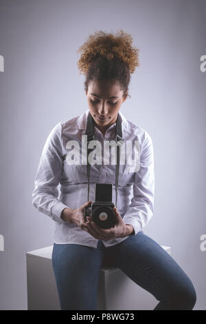 Female photographer clicking photos in photo studio Stock Photo