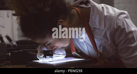 Female photographer using pocket magnifier Stock Photo