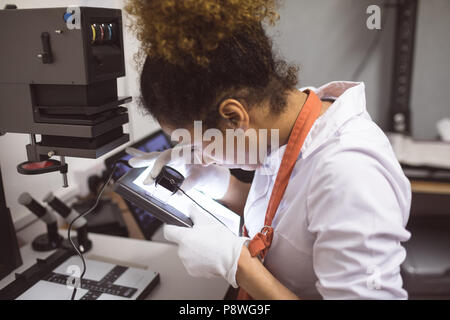 Female photographer using pocket magnifier Stock Photo