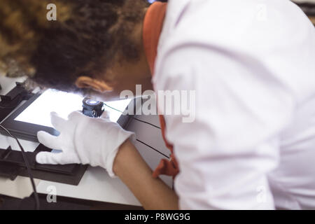 Female photographer using pocket magnifier Stock Photo