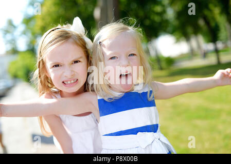 Two little sisters making funny faces outdoors Stock Photo