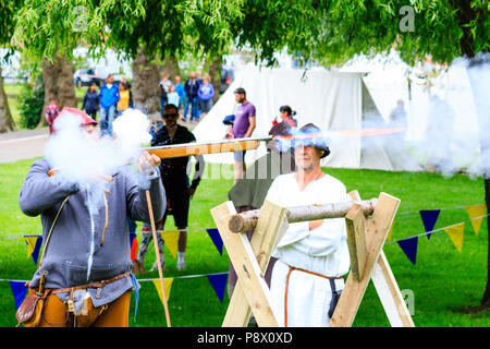 Man in medieval costume, firing harquebus, arquebus, early reconstructed gun, circa 16th century at living history re-enactment event Stock Photo