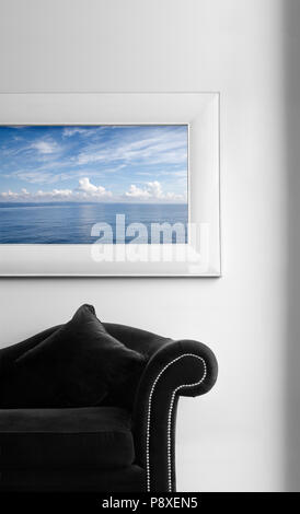 Interior detail with couch and picture on the wall with seascape motif. Photo on the wall by same author. Stock Photo
