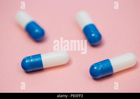 Drugs pills capsules on bright pink background closeup view Stock Photo