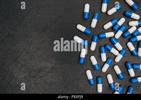 Drugs pills capsules heap on dark background with copy space Stock Photo