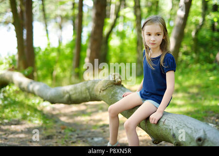 Adorable little girl hiking in the forest on summer day Stock Photo