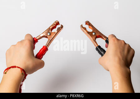 battery jumper cables in hands, on white background Stock Photo