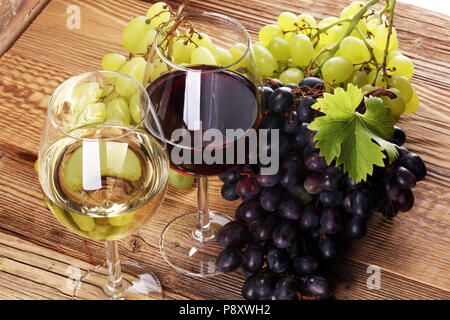 Red Wine and white wine with grapes and glasses on rustic background Stock Photo