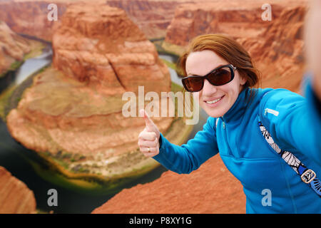 Young tourist taking a photo of herself by famous Horseshoe Bend, Arizona, USA Stock Photo