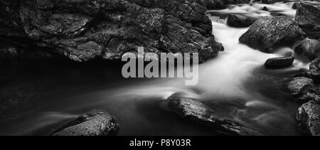 A multi-shot panorama in black and white of swift, rushing water along the Little River in the Great Smoky Mountains National Park. Stock Photo