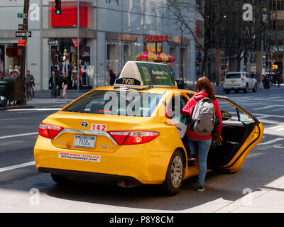 New York City, USA - May 2018: Woman taking taxi on fifth avenue in Manhattan Stock Photo