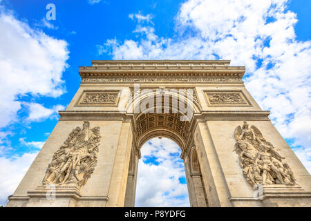 Bottom view of Arch of Triumph at center of Place Charles de Gaulle with clouds and blue sky. Popular landmark and famous tourist attraction in Paris capital of France in Europe.