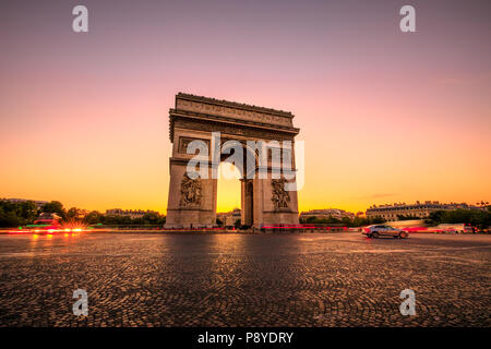 Arch of triumph at twilight. Arc de Triomphe at end of Champs Elysees in Place Charles de Gaulle with cars and trails of lights. Popular landmark and tourist attraction in Paris capital of France. Stock Photo