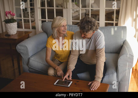 Senior couple using digital tablet on sofa Stock Photo