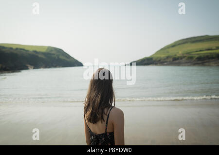 Woman standing on the beach on a breezy day Stock Photo