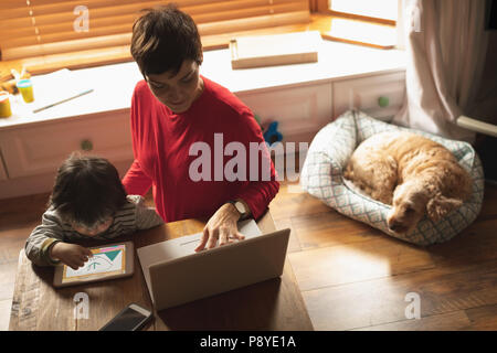 Mother and son using laptop and digital tablet Stock Photo