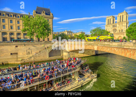 Paris, France - July 1, 2017: Bateaux-Mouches with many tourist during a trip on the River Seine passes under Pont Saint Michel. Cathedral of Our Lady and Conciergerie on the Ile de la Cite. Stock Photo