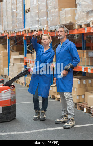 woman and warehouse worker discussing something Stock Photo