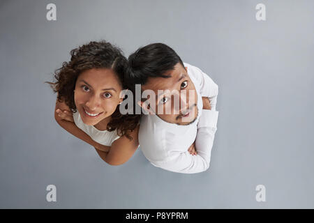 Asian man and hispanic woman with crossed arms isolated on gray background above top view Stock Photo