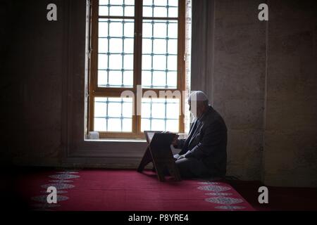 Old man reading Quran in the mosque Turkey Stock Photo