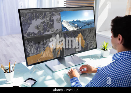 Creative designer editing 3D llndscape in software on computer in office Stock Photo